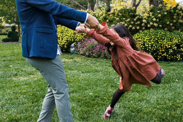 A mother and daughter playing in a garden enhanced by shrub care