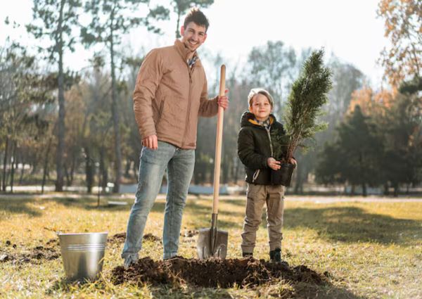 A man digging holes to plant trees with his son