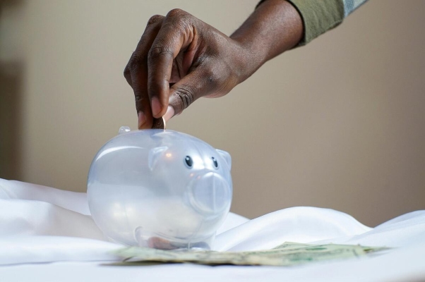 A person putting money into a piggy bank